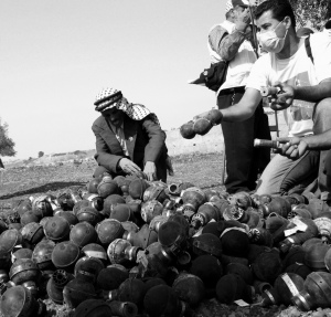 Protesters in Bil In return spent tear gas canisters to the Israeli military